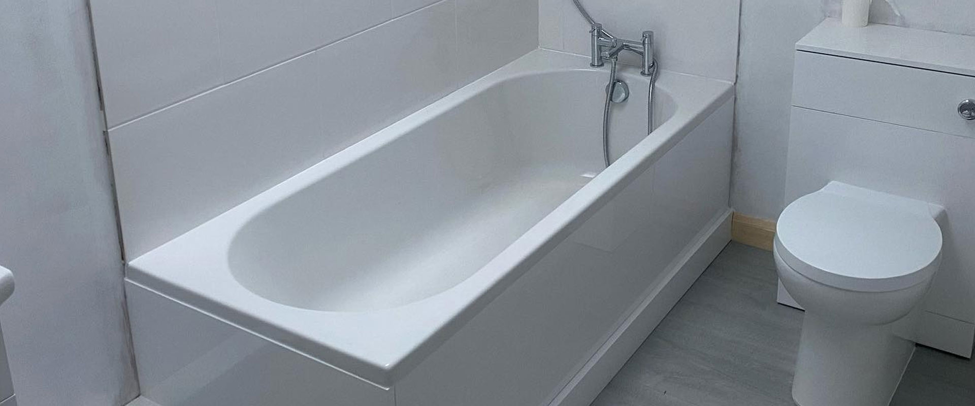 Newly fitted white bathroom with a built in bath and a back to wall toilet