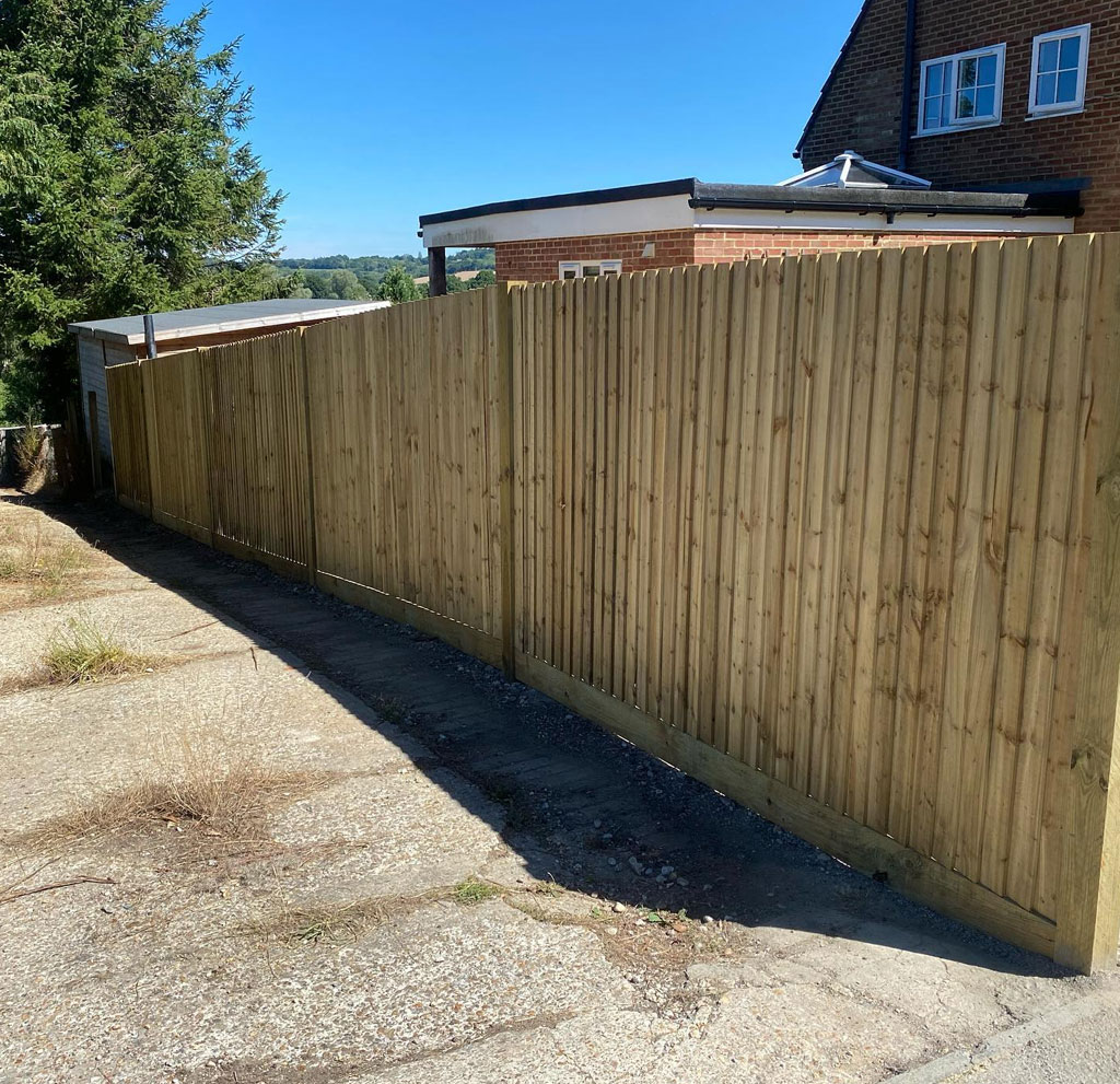New close board fence running alongside a gravel driveway